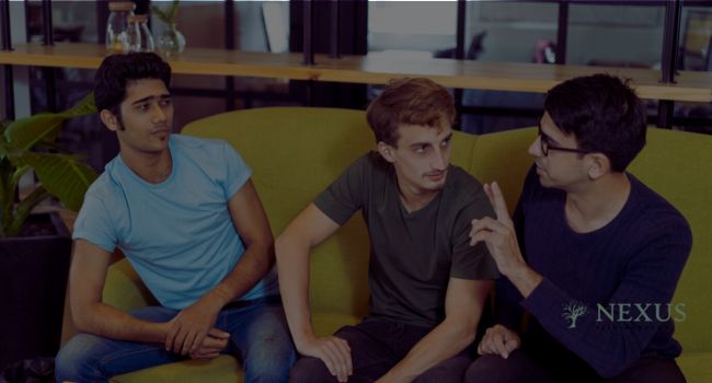 Three teen boys engage in a serious discussion on a couch. Effective anger management strategies for teen boys include communication skills, mindfulness, physical activity, and conflict resolution techniques.