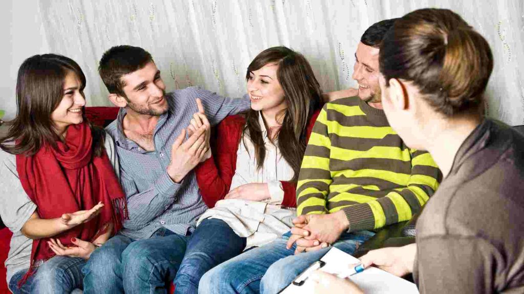 Group of teens engaging in a therapy session, illustrating the benefits of interpersonal therapy techniques in fostering communication, trust, and emotional growth.