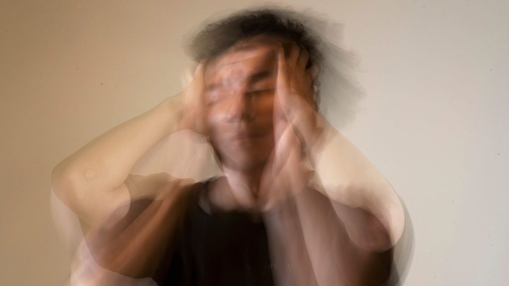 A blurred image of a distressed teen holding their head, symbolizing anxiety and emotional turmoil. Highlights the need for trauma-focused therapy for teens.