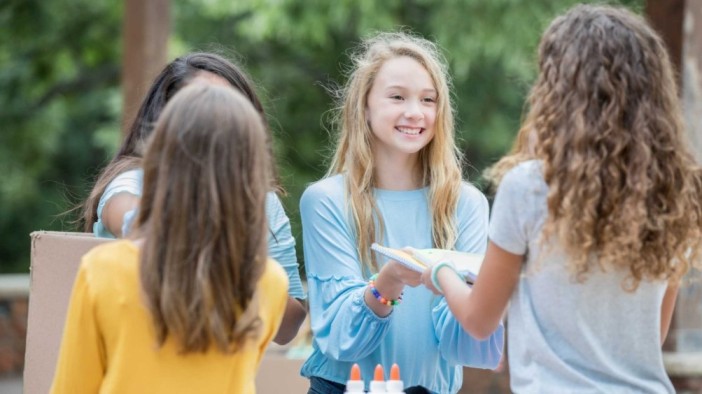 Teens engage in a supportive discussion outdoors, practicing key principles of motivational interviewing like active listening, encouragement, and goal setting.