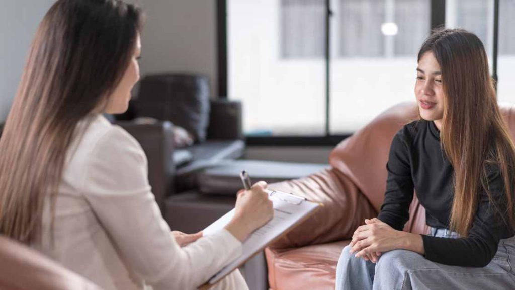 Teen girl speaking with a therapist in a cozy office, highlighting the process of diagnosing and treating eating disorders.