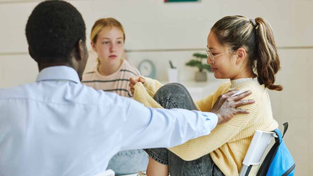 Teen girl participating in a supportive therapy session with peers, illustrating the benefits of psychodrama therapy.