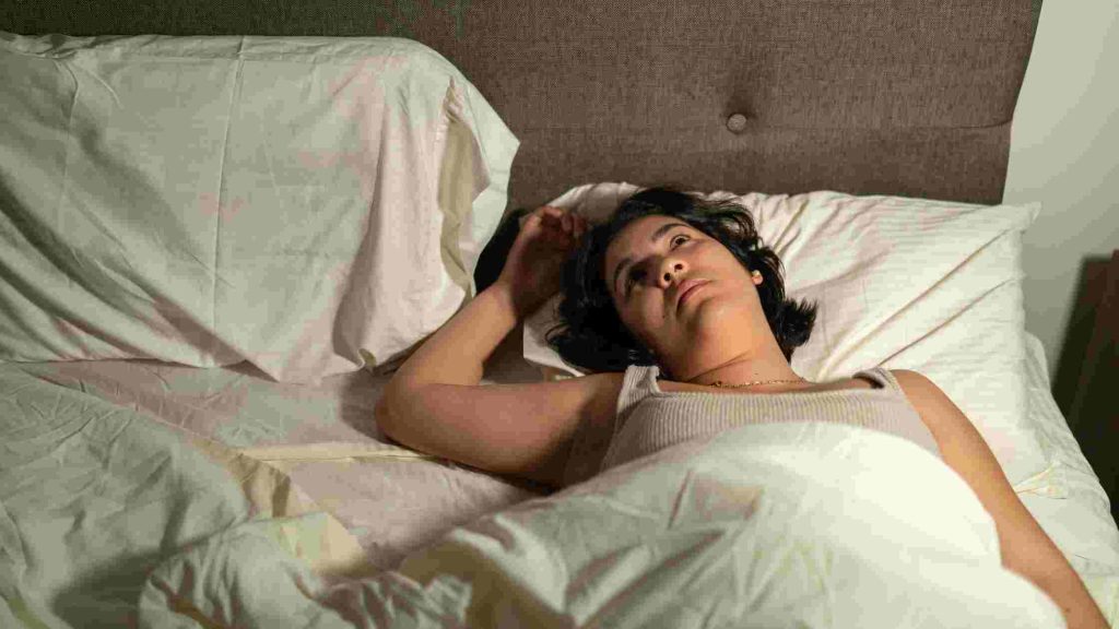 Teen lies awake in bed, wide-eyed and restless, unable to fall asleep.