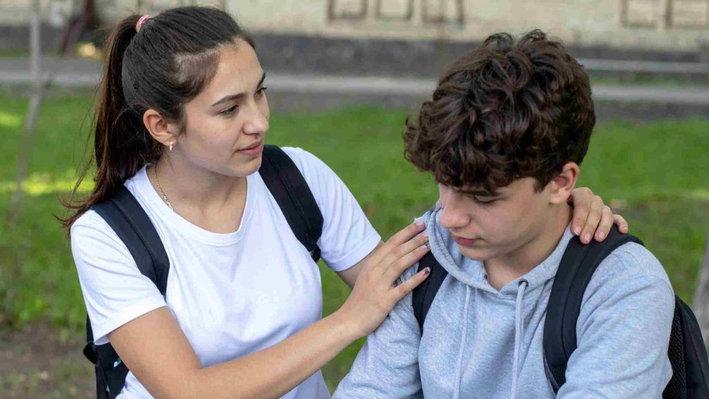 Teen comforting a worried classmate, symbolizing social and school-related struggles linked to OCD in adolescents.