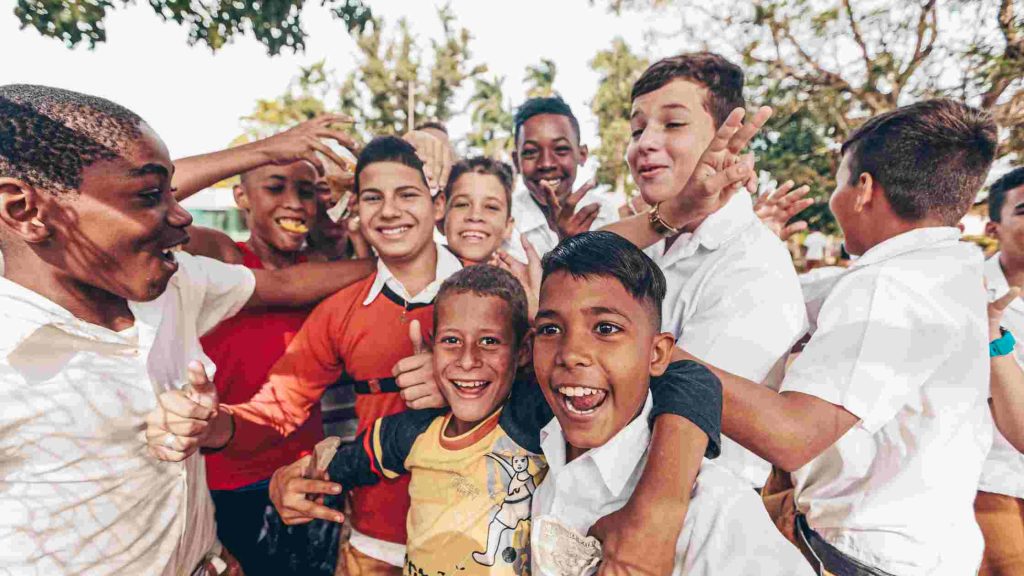 Group of smiling boys playing together outdoors, representing the supportive and positive environment of a boys’ home.